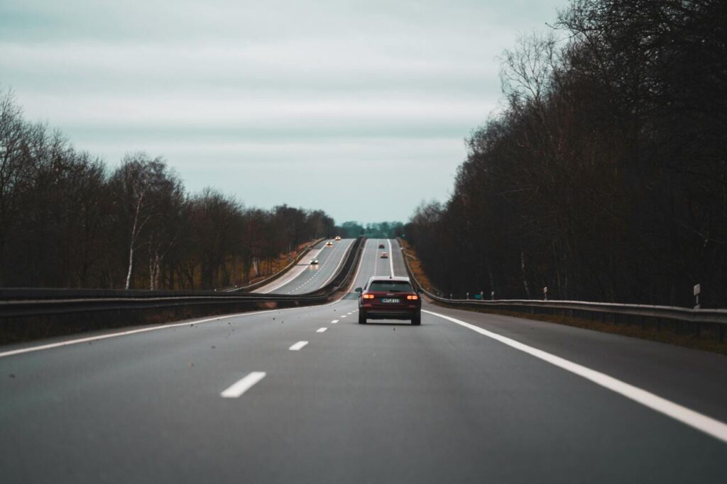 A car driving along the highway in autumn A car driving along the highway before an uphill stretch