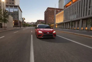 Червона Toyota Camry XV80 на міській дорозі, вигляд спереду