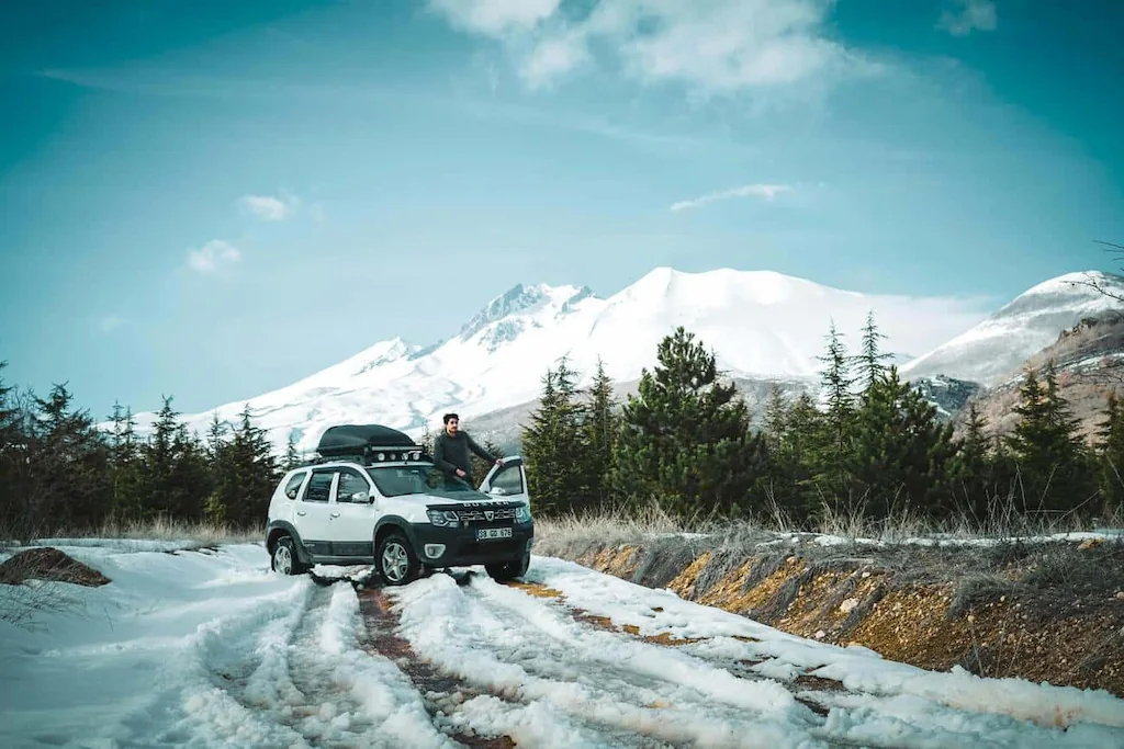 Турист зупинився на зимовій дорозі Позашляховик припаркований на засніженій дорозі