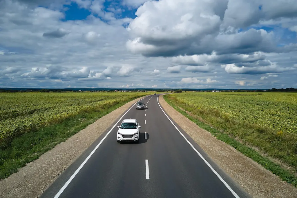 Траса відстань Київ Черкаси серед полів із авто в дорозі