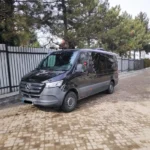 Мінівен Mercedes Sprinter для трансферу Буковель Львів біля огорожі