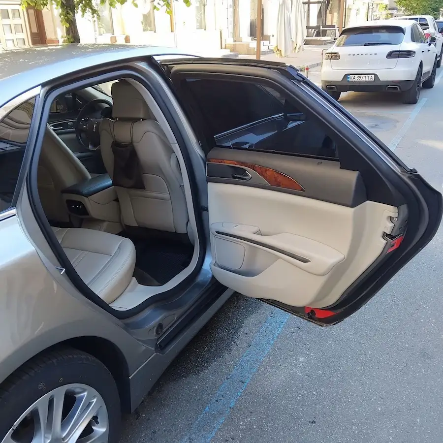 Відчинені задні двері й світлий шкіряний салон Lincoln MKZ для поїздки зі Львова до Берліна